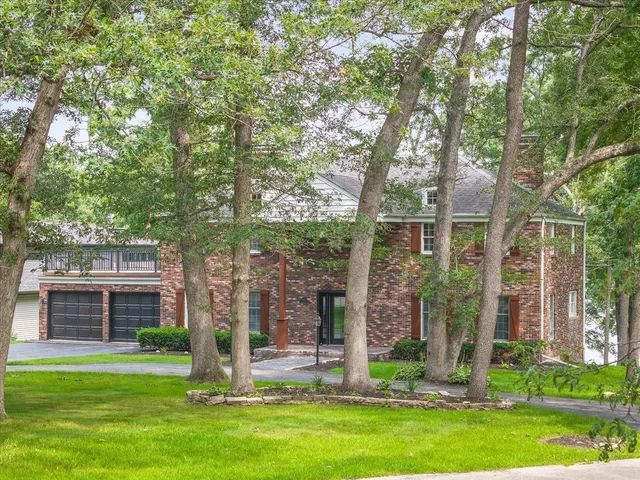 a view of a brick house with a yard and plants