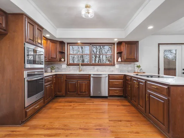 a kitchen with granite countertop wooden cabinets and stainless steel appliances