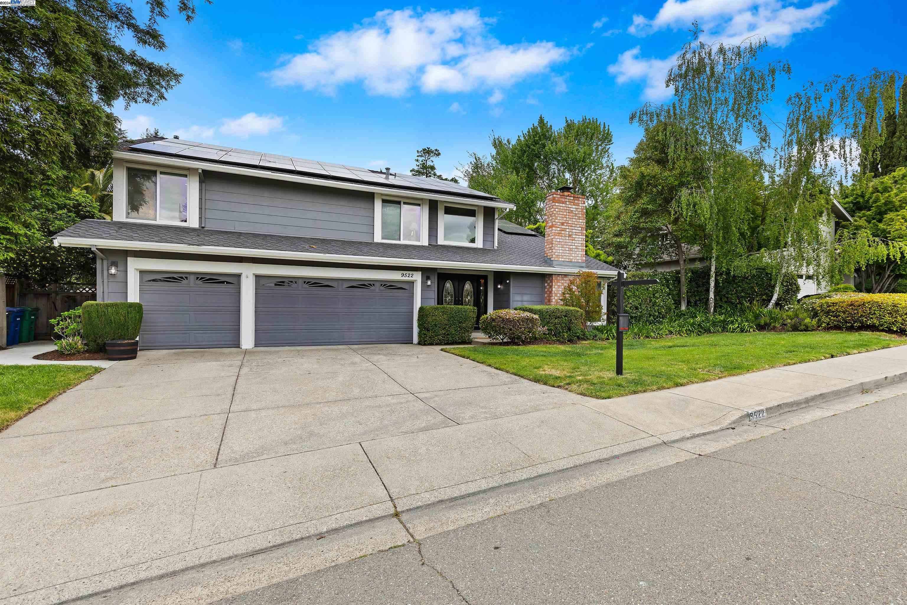 a front view of a house with a yard and trees