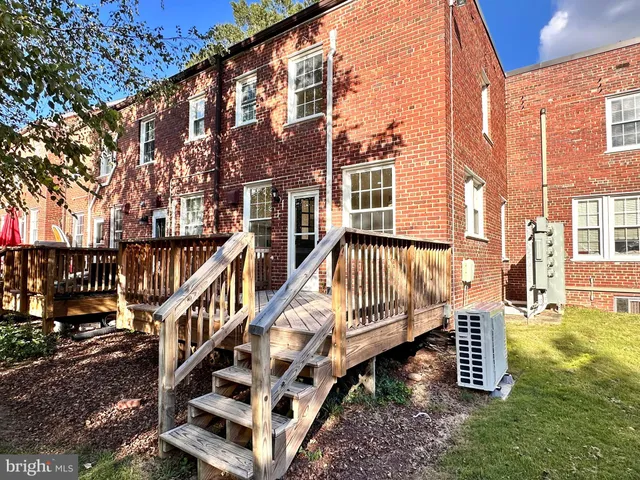 a view of a house with a big yard and large trees