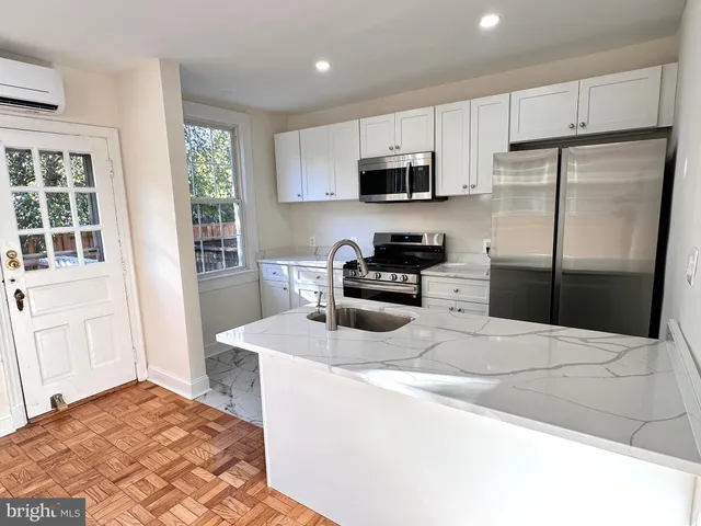 a kitchen with stainless steel appliances a refrigerator sink and microwave