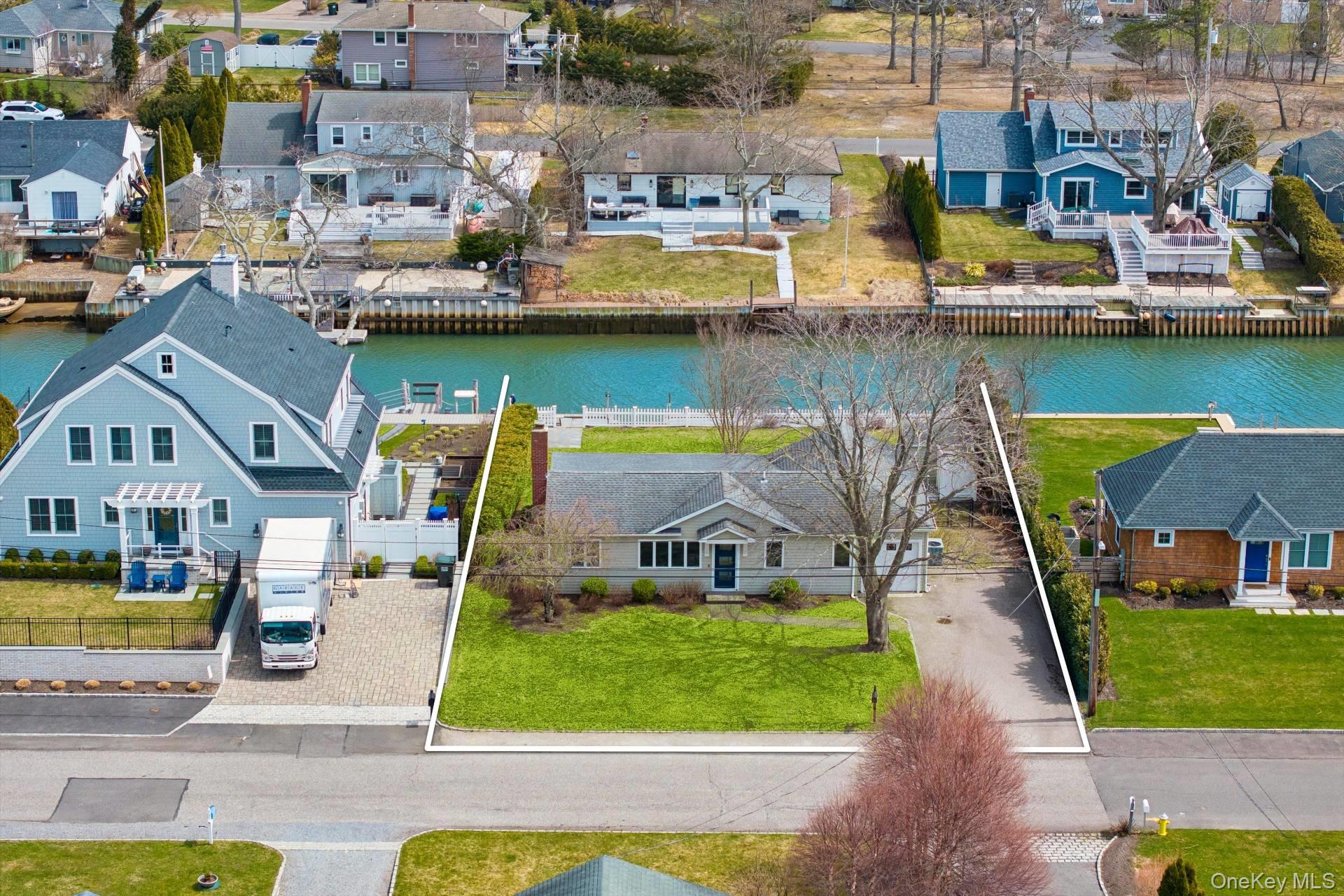 21 Tarpon Road East Quogue, NY 11942 - Photo 2 of 18 an aerial view of a house with a swimming pool patio and lake view