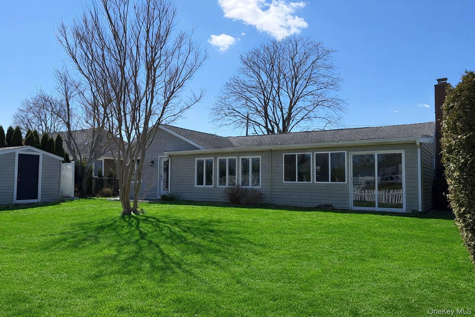 21 Tarpon Road East Quogue, NY 11942 - Photo 3 of 18 a view of a house with a yard and large trees