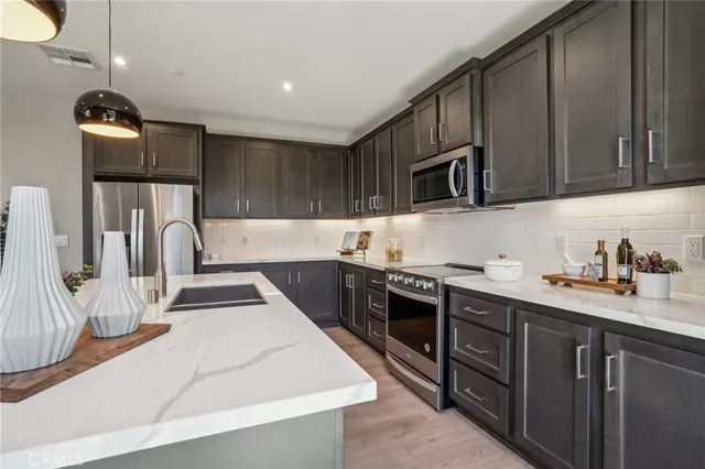 a kitchen with kitchen island a stove a sink a oven a dining table and chairs