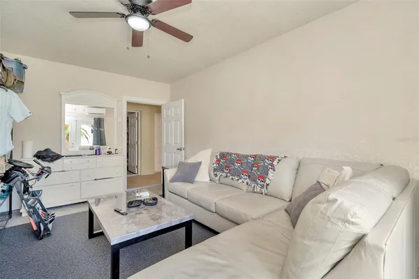 a living room with furniture and a ceiling fan
