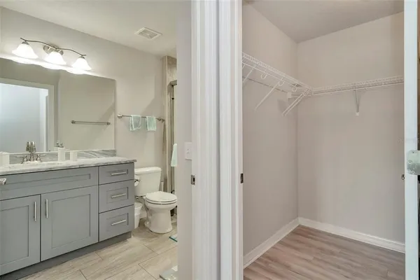 a bathroom with a granite countertop sink a toilet and a shower