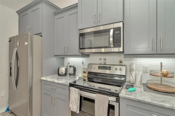a kitchen with stainless steel appliances granite countertop a stove a microwave and cabinets