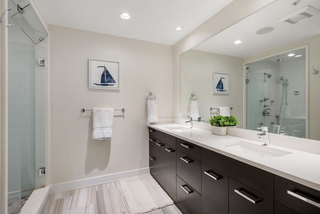 405 West First Street, Unit 303 Boston, MA 02127 - Photo 17 of 29 a spacious bathroom with a double vanity sink a mirror and a bathtub