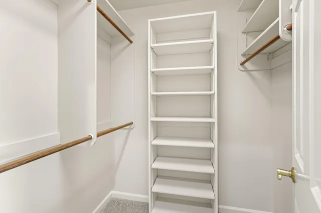 an empty room with windows and fireplace