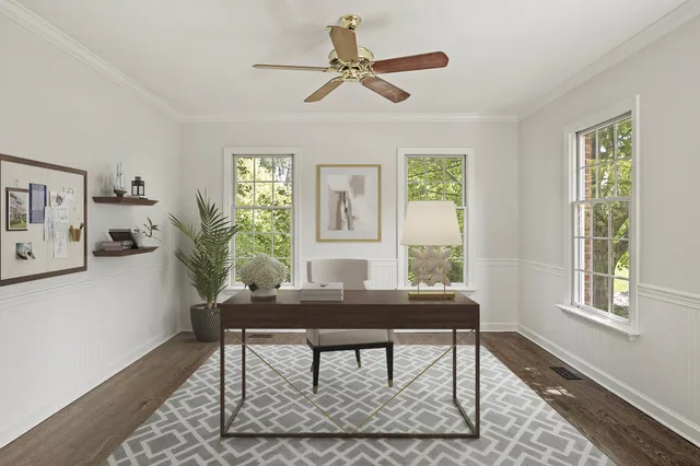 an empty room with wooden floor chandelier and windows