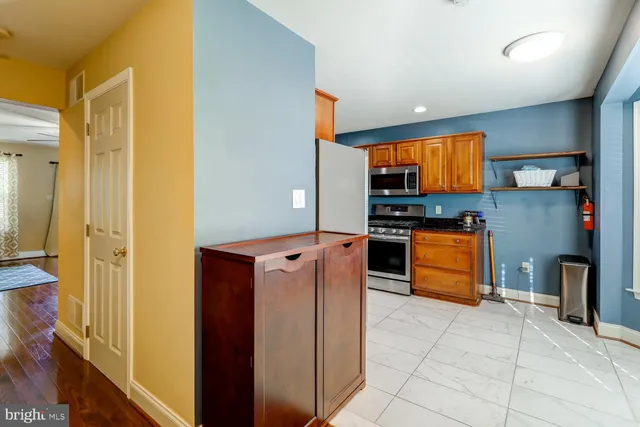 a kitchen with stainless steel appliances granite countertop a refrigerator and a stove top oven