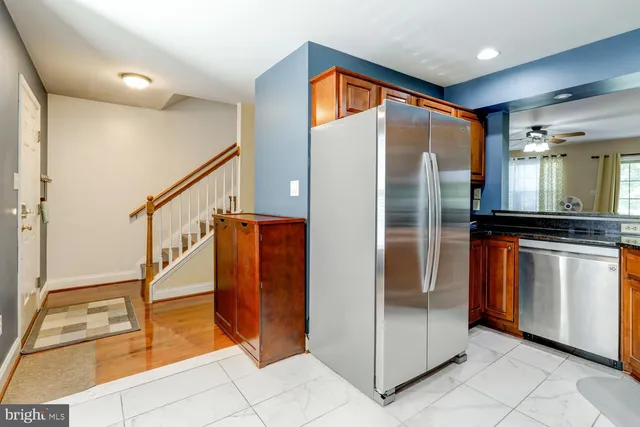 a kitchen with stainless steel appliances granite countertop a refrigerator and a stove top oven