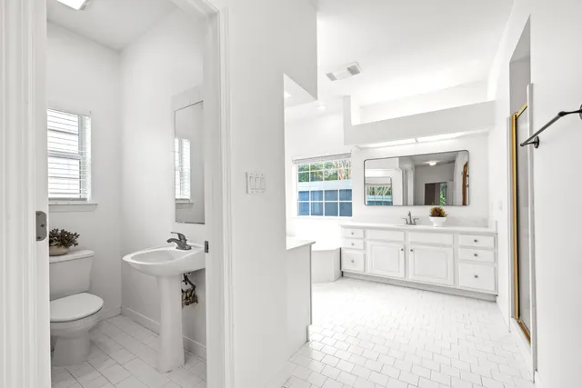 a view of a bathroom with sink mirror and window