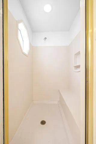 a bedroom with a bed television and a large window