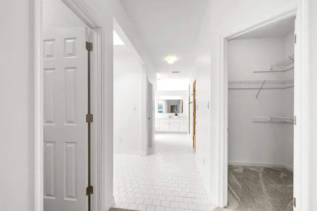 a view of an empty room with chandelier fan and a window