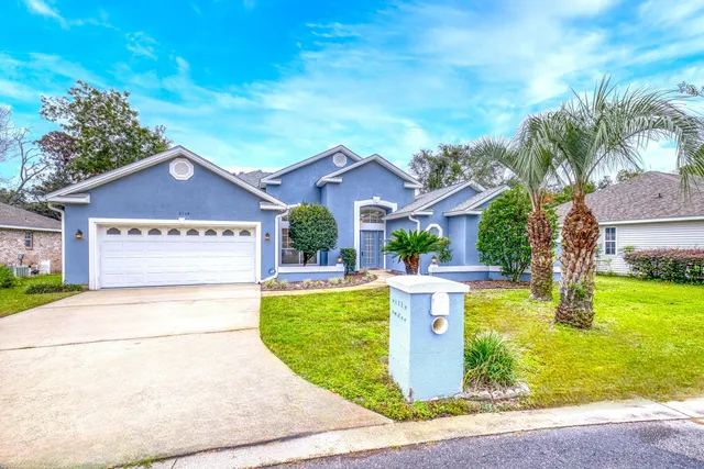 a view of a house with garden and a tree