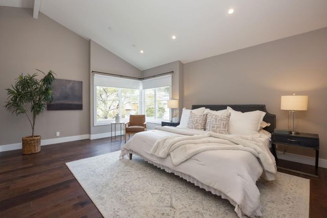 a large bedroom with bed and a potted plant