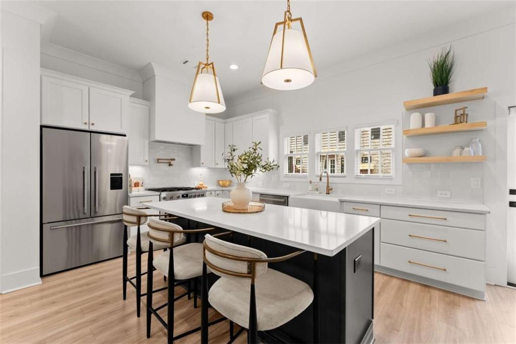 338 Sugarview Road Sugar Hill, GA 30518 - Photo 13 of 74 a kitchen with stainless steel appliances a dining table chairs and wooden floor