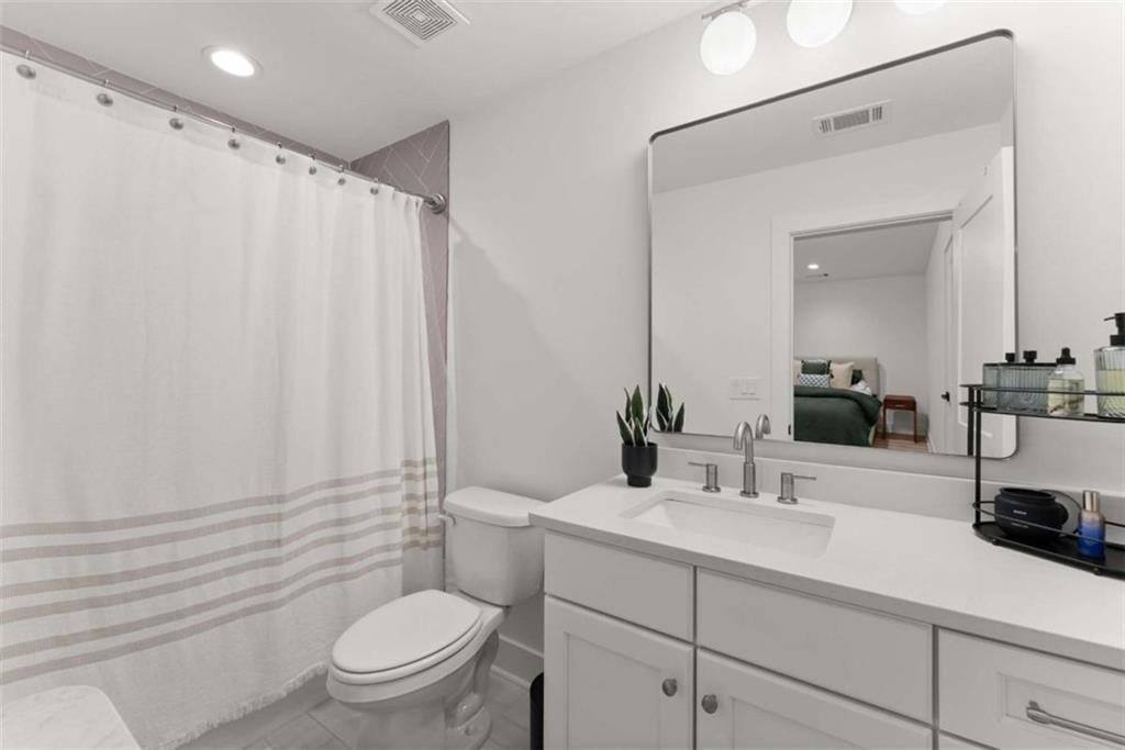 338 Sugarview Road Sugar Hill, GA 30518 - Photo 27 of 74 a bathroom with a sink a toilet a mirror and shower curtain