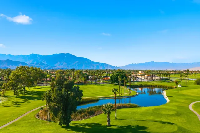 a view of a swimming pool is middle in the garden