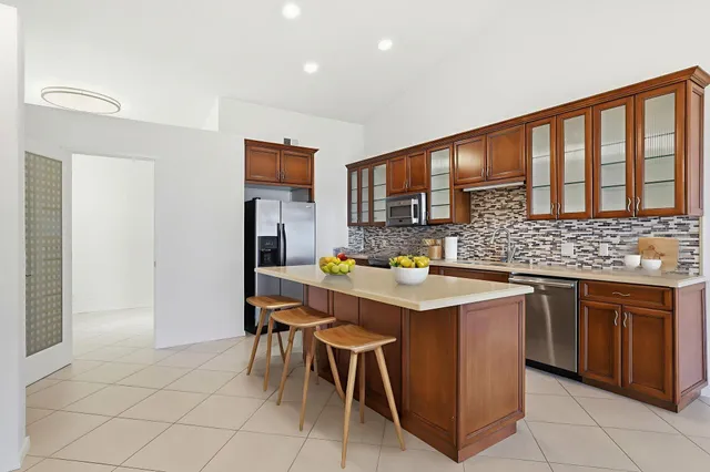 a kitchen with stainless steel appliances granite countertop a sink counter space and a refrigerator