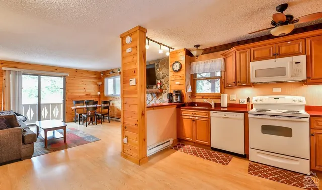 a kitchen with stainless steel appliances granite countertop a stove a sink dishwasher and a dining table with cabinets