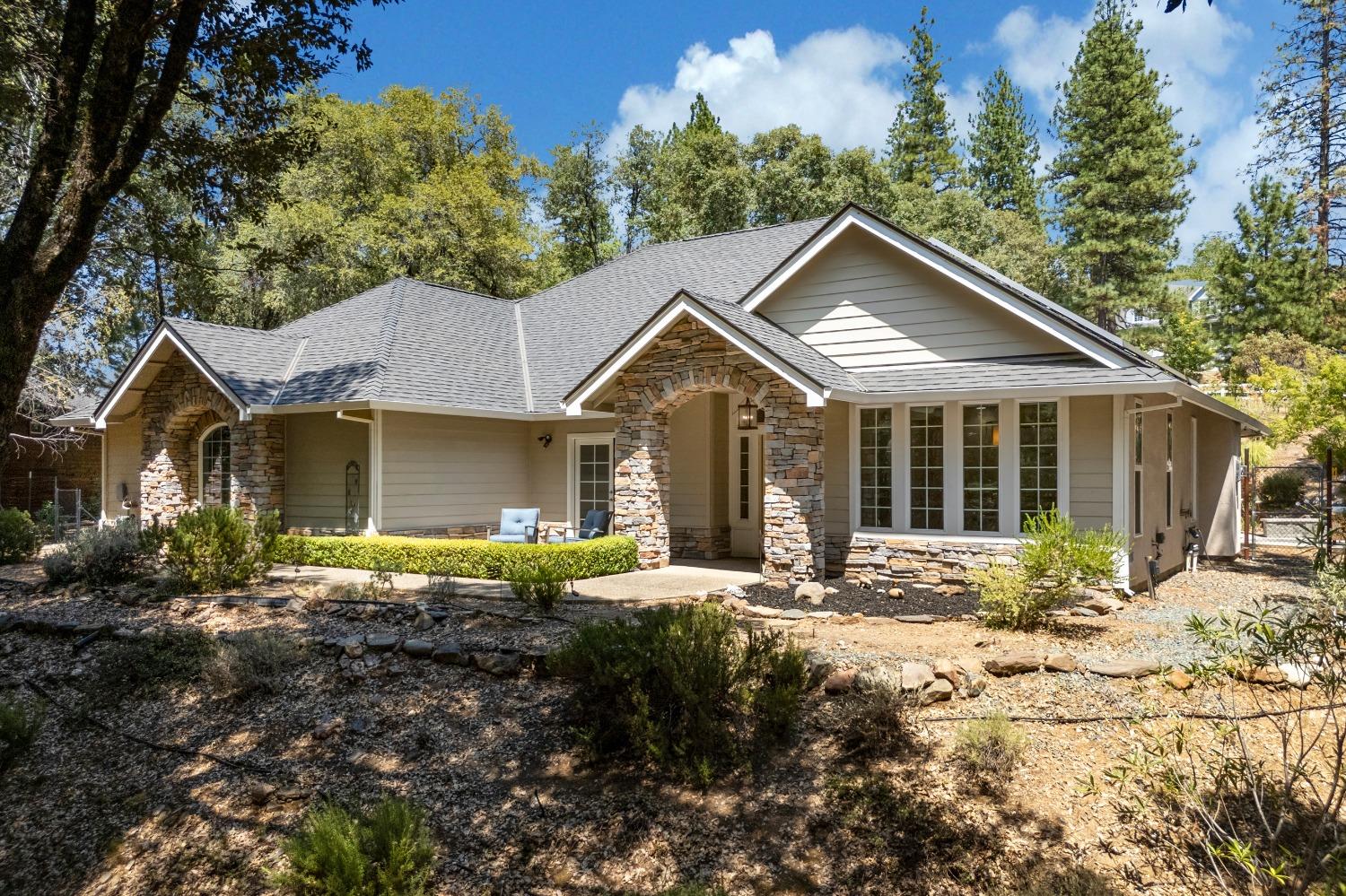 a front view of a house with a yard and outdoor seating