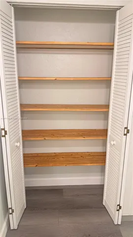 an empty room with wooden floor and a window