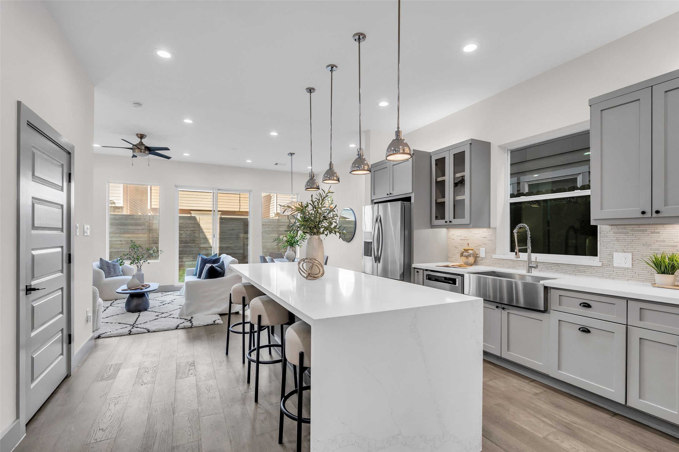 a large kitchen with kitchen island a large window a sink and cabinets