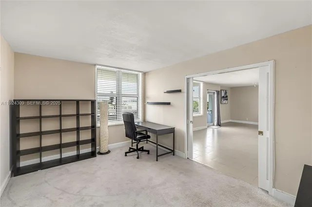 a view of a livingroom with workspace and a window