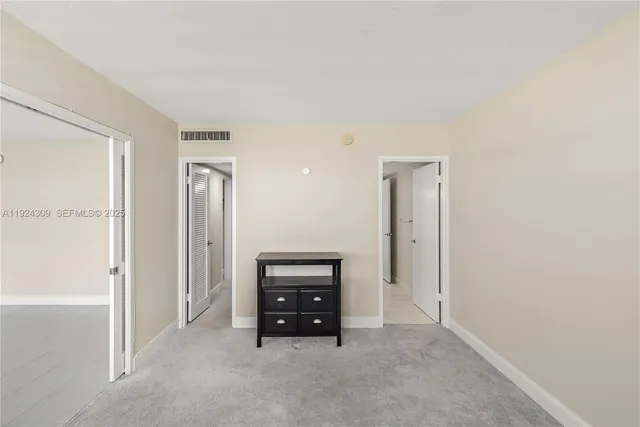 an empty room with windows and cabinet