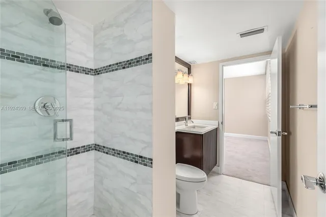 a bathroom with a shower a toilet and sink