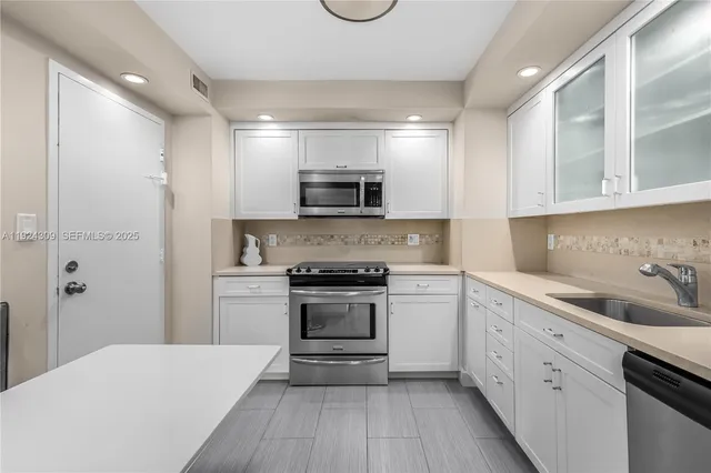 a kitchen with granite countertop a sink and steel appliances