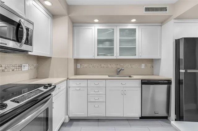 a kitchen with stainless steel appliances granite countertop a stove and a refrigerator