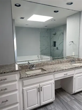 a bathroom with a granite countertop sink and a mirror