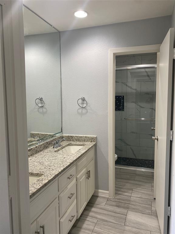 6005 Black Berry Lane Dallas, TX 75248 - Photo 20 of 22 a bathroom with a granite countertop sink a mirror and shower
