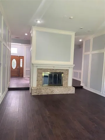 a view of empty room with wooden floor and fireplace