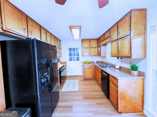 a kitchen with stainless steel appliances granite countertop a refrigerator a stove and a sink