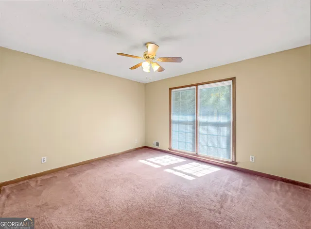 an empty room with closet and a chandelier fan