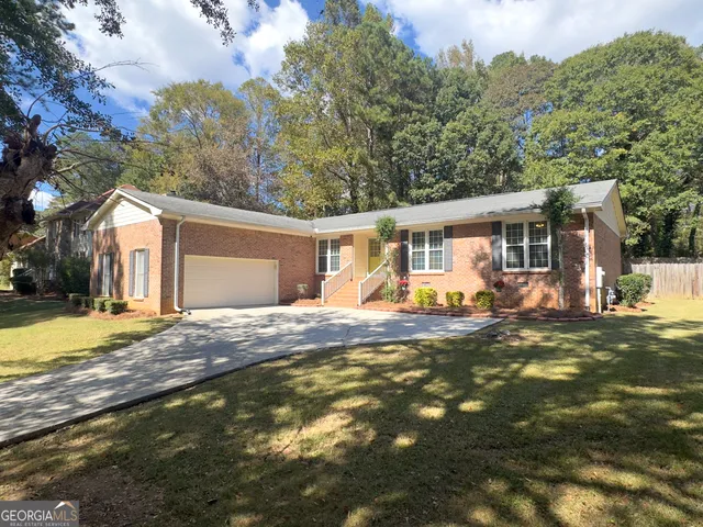 a view of a house with backyard and a tree