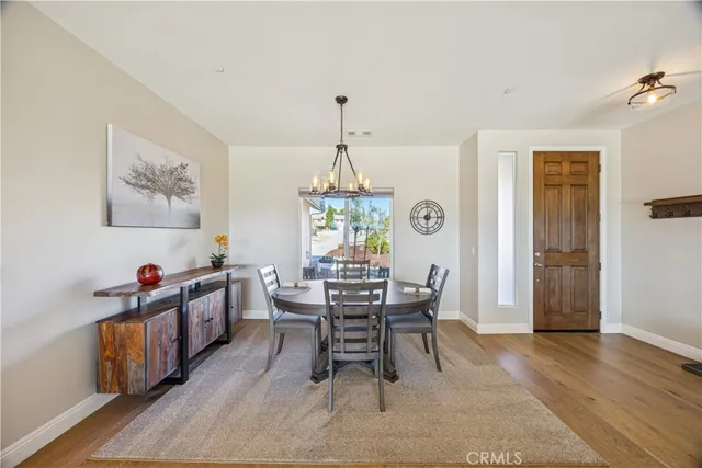 a dining room with furniture a chandelier and wooden floor