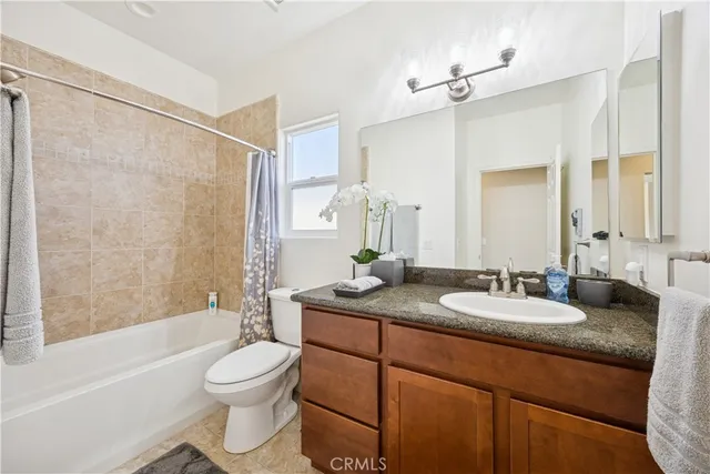 a bathroom with a granite countertop sink toilet a large mirror a bathtub and shower