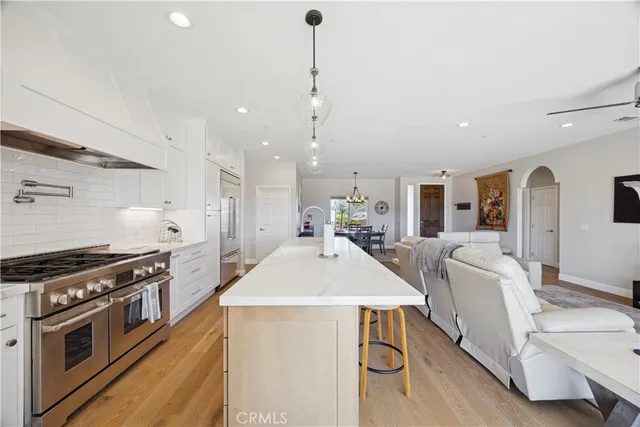 a kitchen with stainless steel appliances kitchen island a stove a sink a counter top space and cabinets