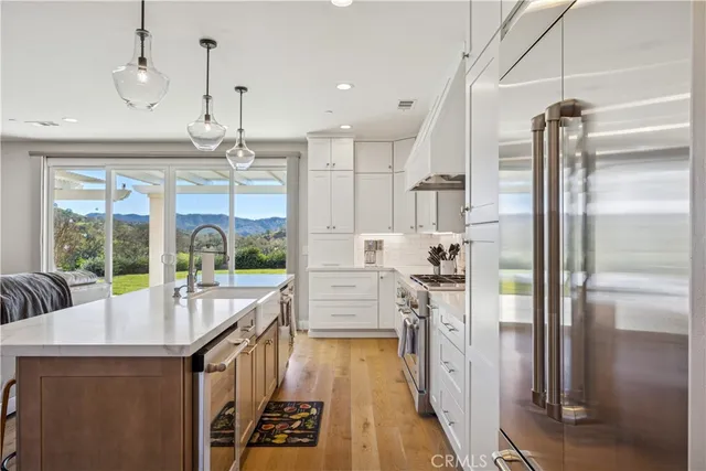 a kitchen with counter top space wooden floor and stainless steel appliances