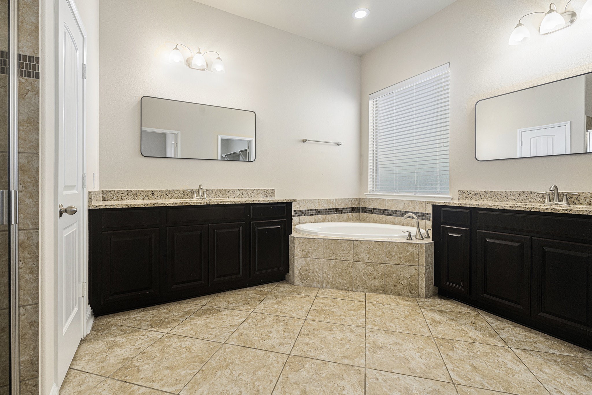 18614 Rimini Ridge Court Cypress, TX 77429 - Photo 15 of 35 a spacious bathroom with a granite countertop sink a mirror and a bathtub