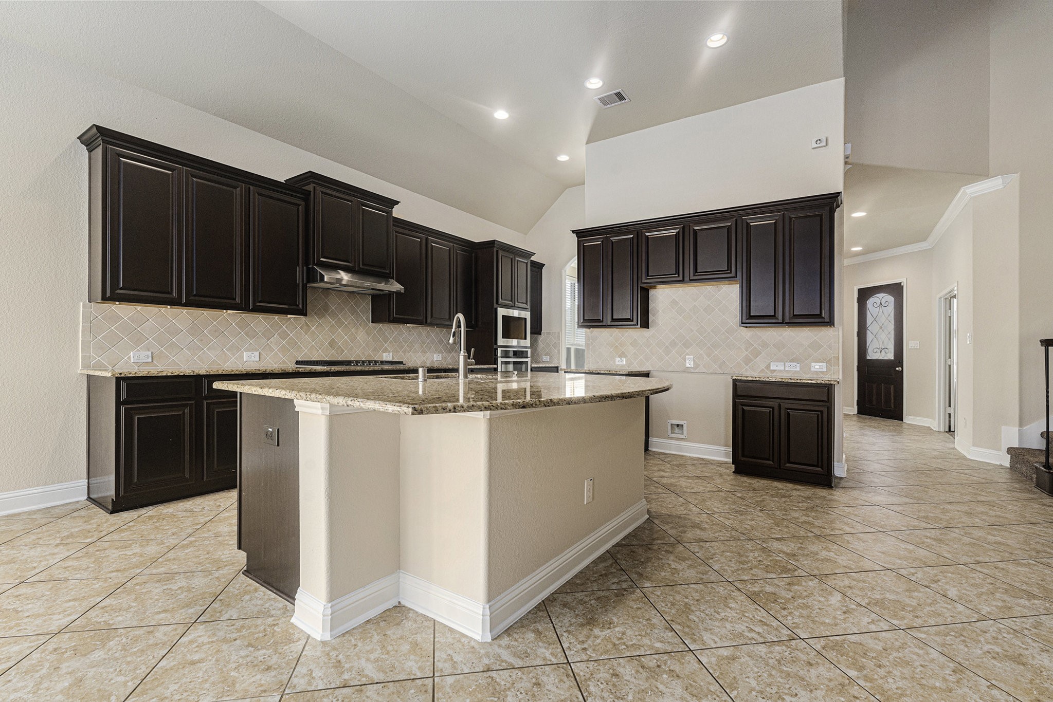 18614 Rimini Ridge Court Cypress, TX 77429 - Photo 6 of 35 a kitchen with kitchen island granite countertop a stove top oven microwave and cabinets