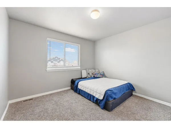 a bedroom with a bed and painting on the wall