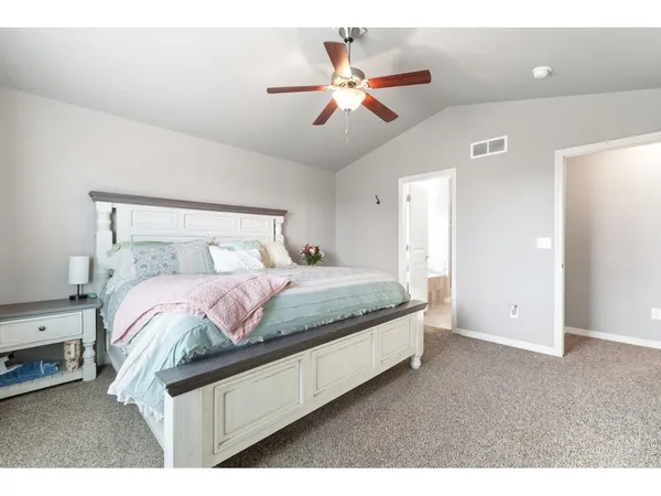 a bedroom with a bed and a ceiling fan