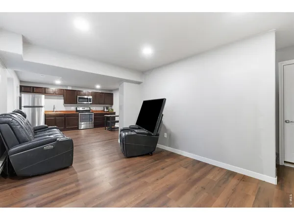 a living room with furniture and a wooden floor