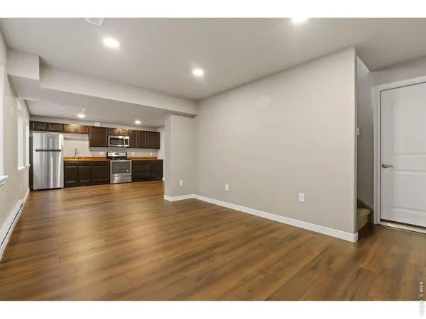 a view of empty room with wooden floor